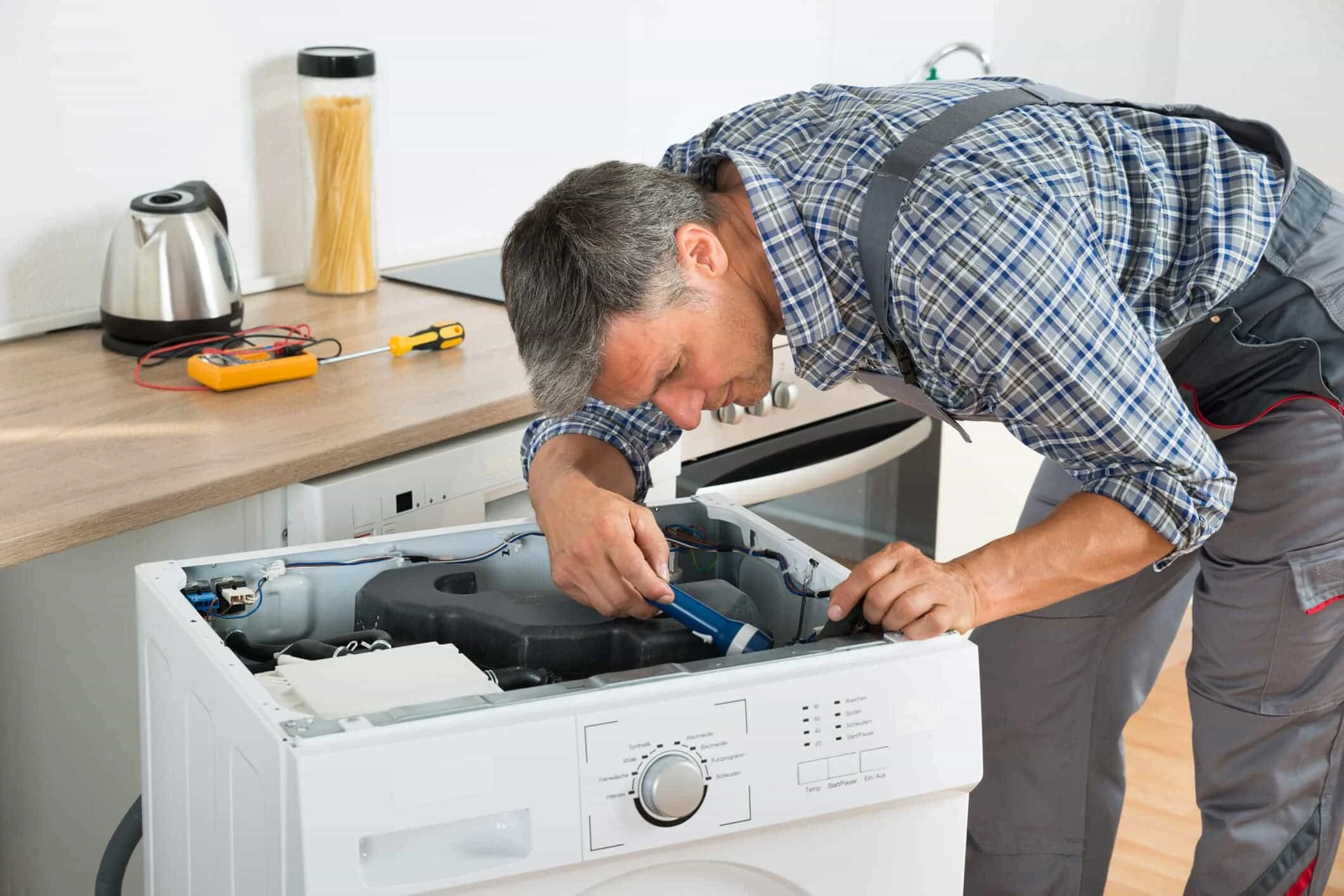 A technician repairing a dryer in a Lady Lake home