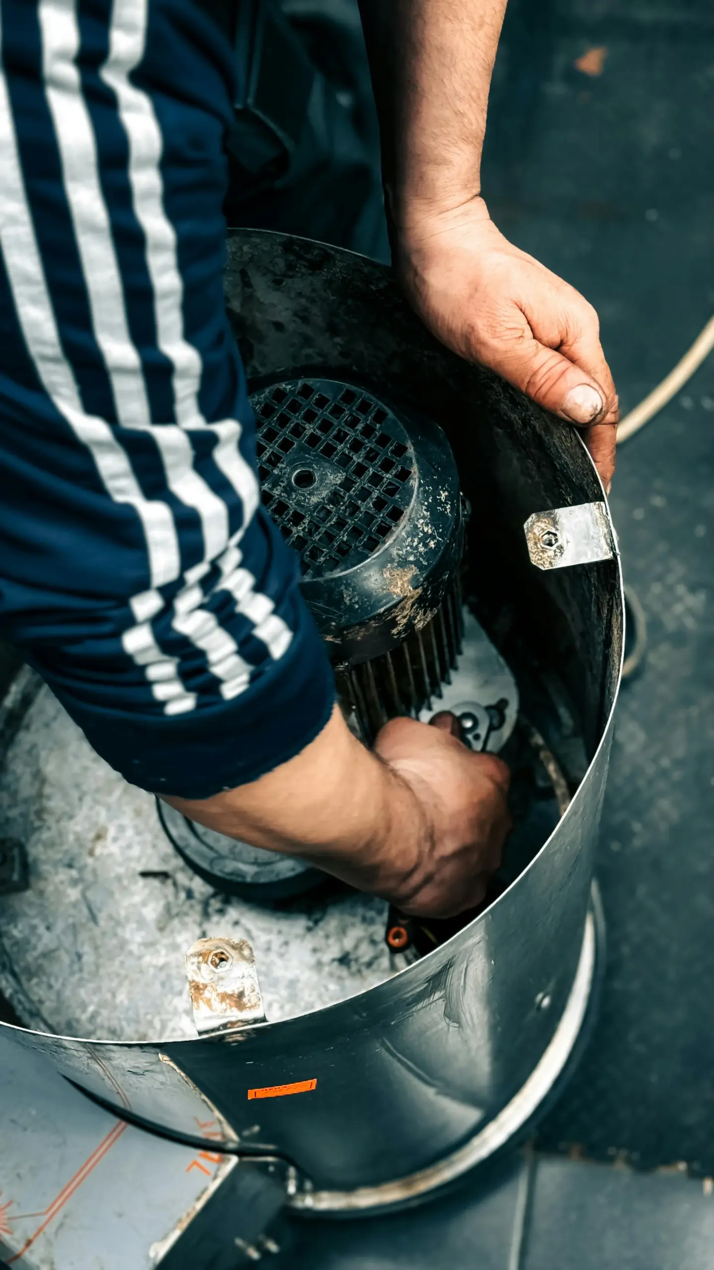 A worker troubleshooting a noisy dryer in a Wildwood laundry room